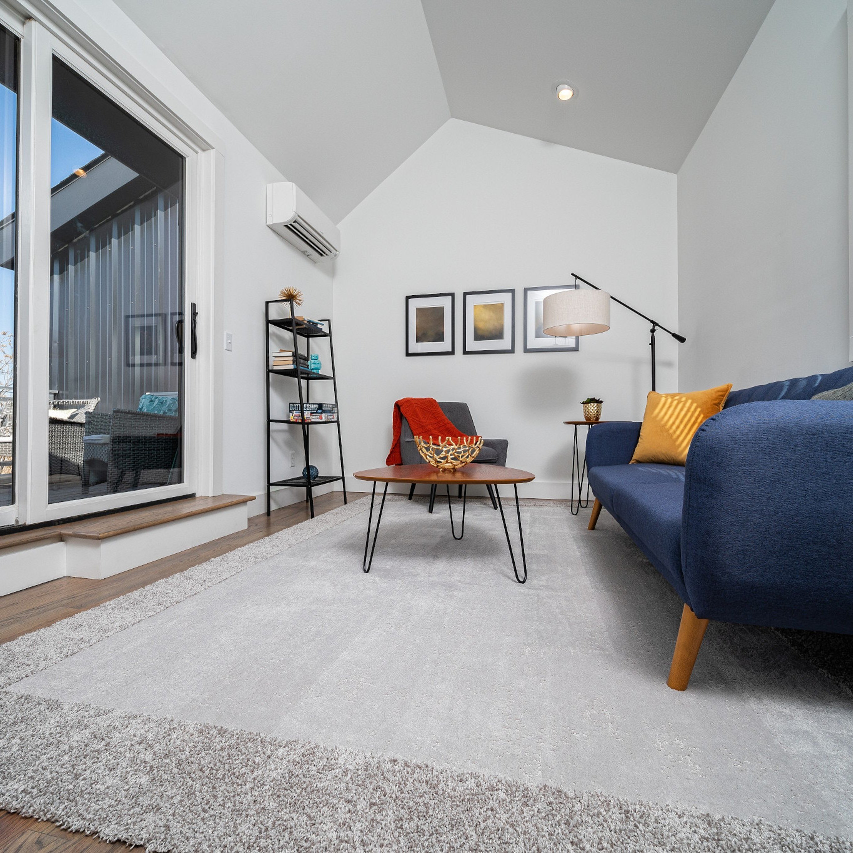 Living room with a blue couch and large gray area rug - Carpet Binding & Serging from The Carpet Yard in McLean, VA