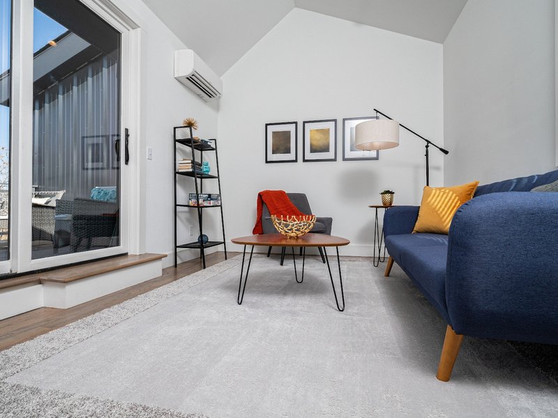 Living room with a blue couch and large gray area rug - Carpet Binding & Serging from The Carpet Yard in McLean, VA